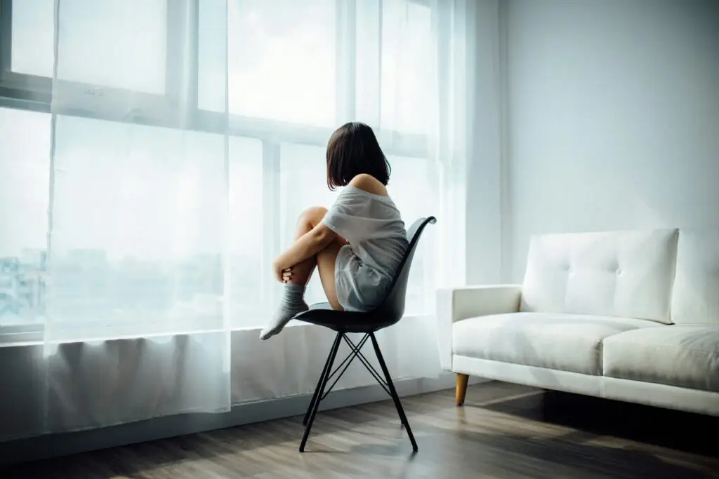 woman sitting in a chair looking out the window