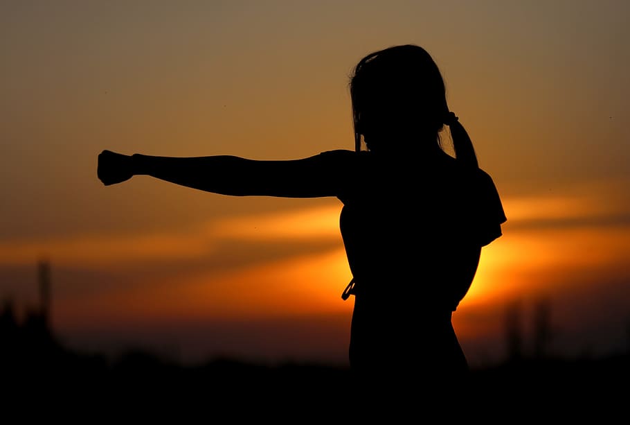 a sillouette of a woman punching