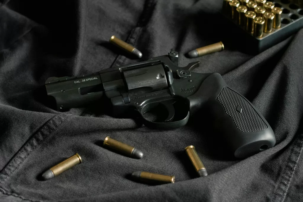 a revolver laying on a table with ammo