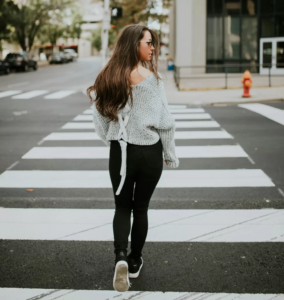 woman walking across a crosswalk